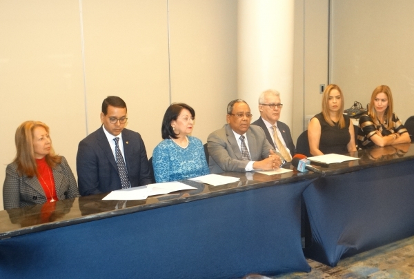 Evérgito Peña Acosta ofrece el informe en la rueda de prensa. Lo acompañan Dolly Martínez; Elías Dinzey, Rosa Rita Álvarez, Moisés Álvarez, Rosa Rijo y Julissa Báez.