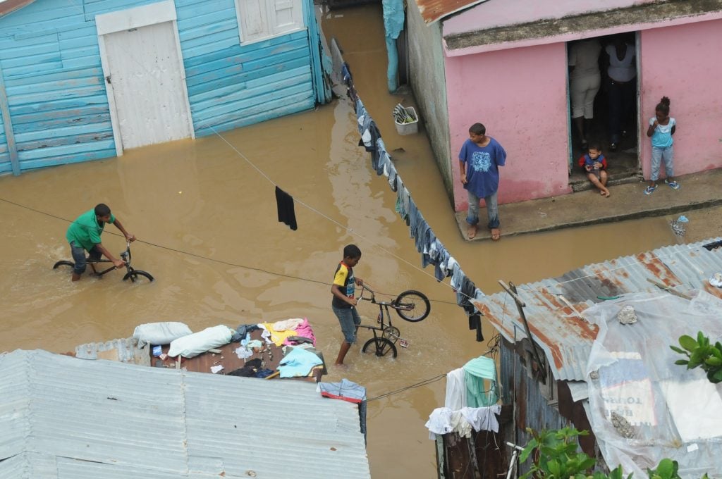Un grupo de nios juegan el el barrio La Barquita en donde el agua del rio ozama tiene todas la casas inundadas debido a la lluvia caida en el dia de ayer en la ciudad de Santo Domingo.martes 5 de julio 2011. Foto Jorge Cruz